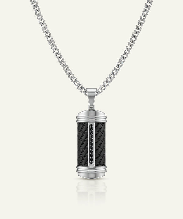 Silver pendant with black woven design on a white background
