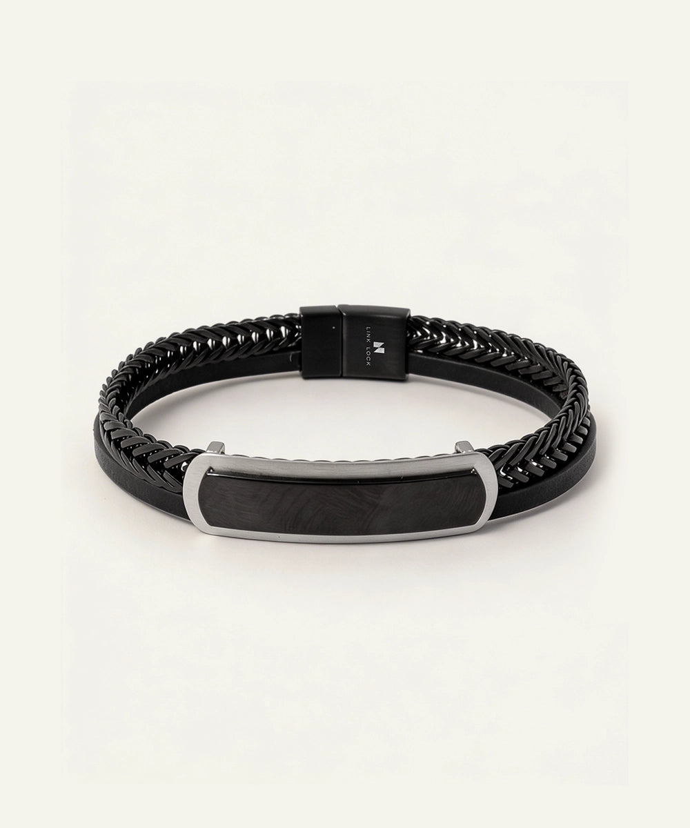 Black braided leather bracelet with a silver tag on a light gray background