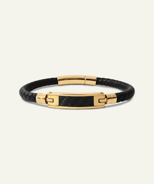 Black leather bracelet with gold accents on a white background