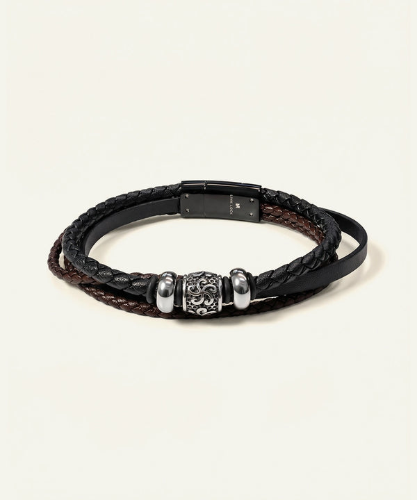 Black braided leather bracelet with silver beads on a light gray background