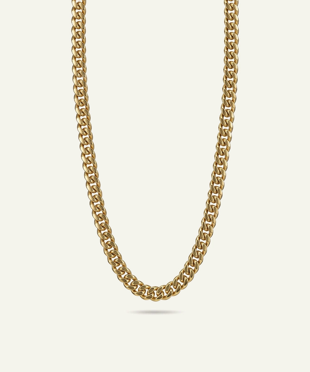 Gold chain necklace on a light beige background