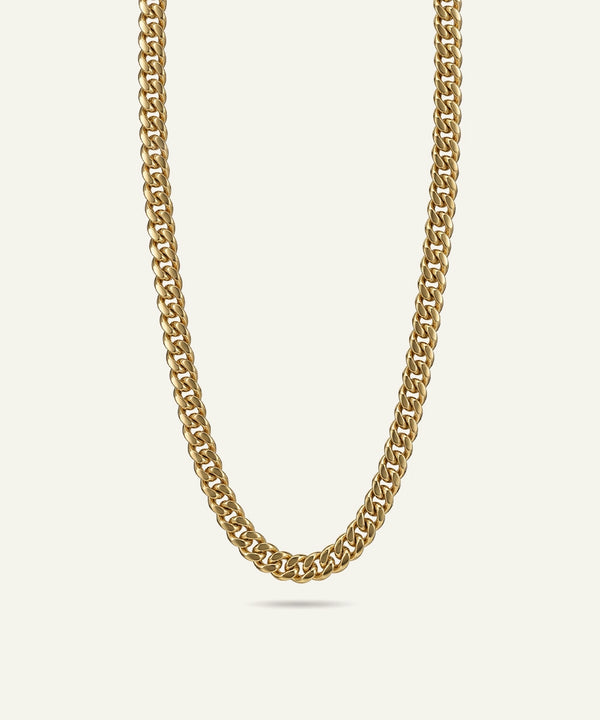Gold chain necklace on a light beige background