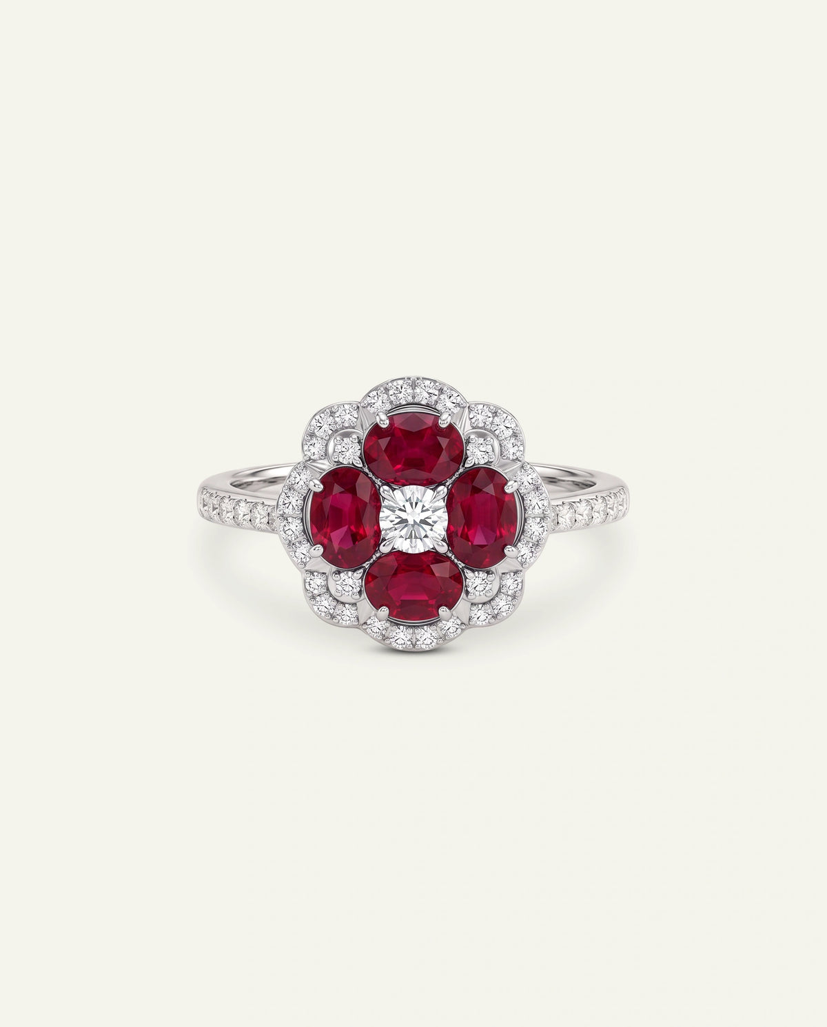 A floral cluster ring featuring four oval-cut deep red rubies surrounded by a halo of small clear stones, with a central diamond and a polished silver-toned band, set against a light cream background.