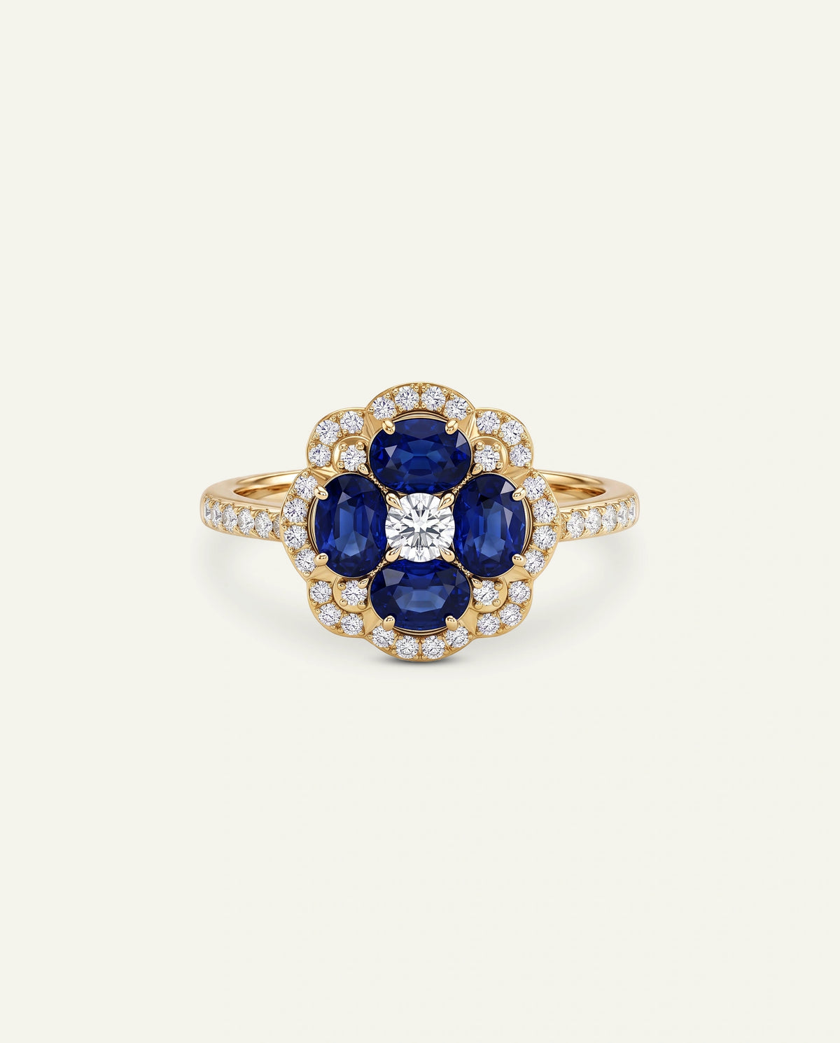 A yellow gold ring featuring a flower-shaped cluster with four oval-cut deep blue sapphires and a central round brilliant-cut diamond, surrounded by a halo of small pavÃ©-set diamonds on a light cream background.