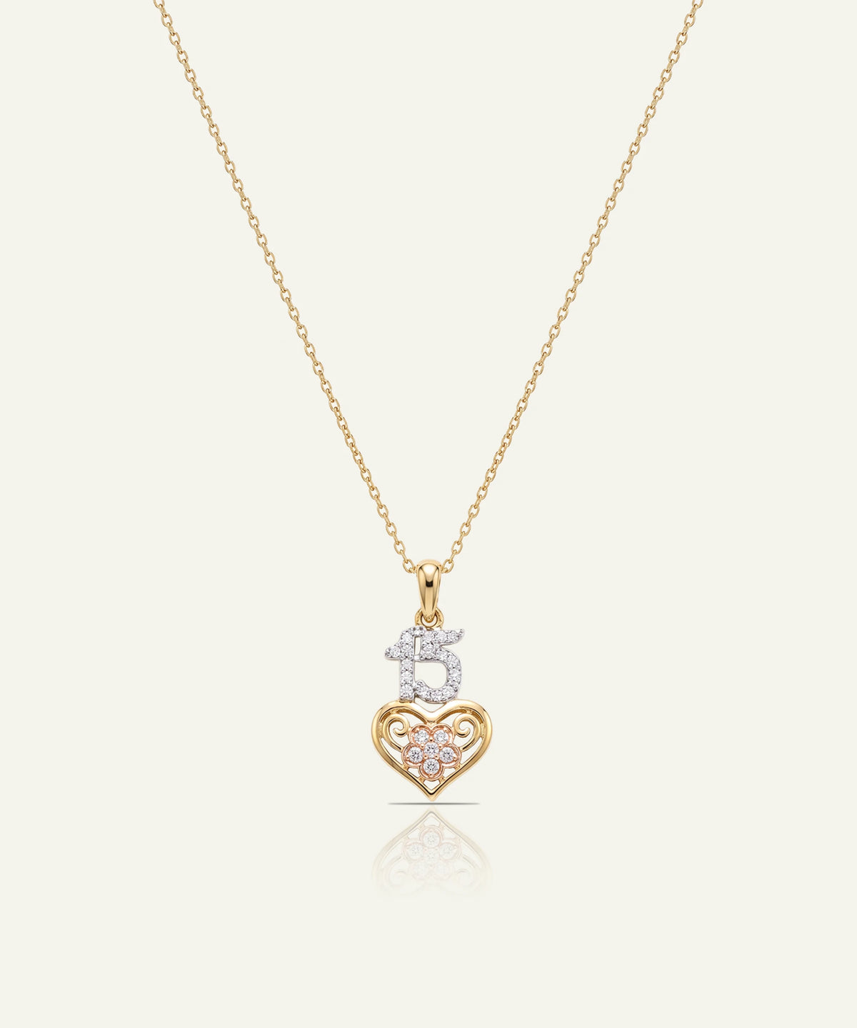 "Gold chain necklace with a pendant featuring a diamond-paved '15' on a gold heart accent."