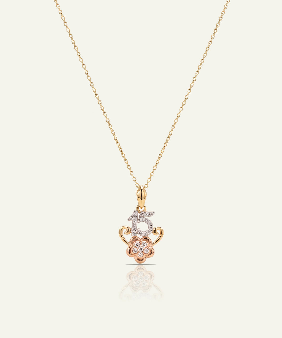 "Gold chain necklace with a pendant featuring a diamond-paved '15' on a rose gold flower motif."