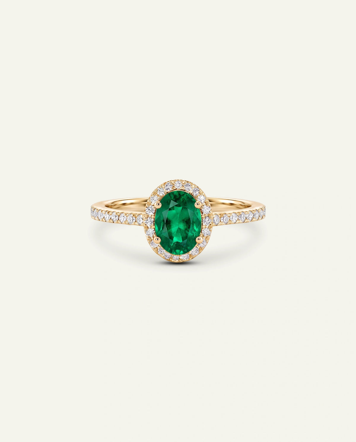 A yellow gold ring featuring an oval-cut green emerald center stone surrounded by a halo of small clear stones, with the band itself paved with clear stones, set against a solid off-white background.