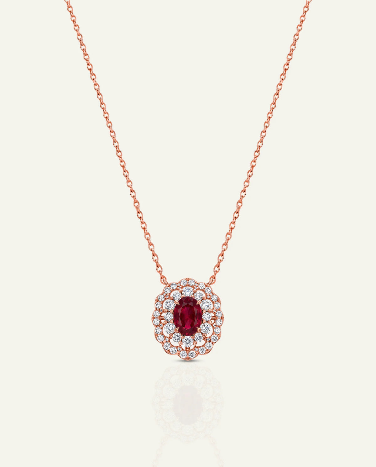 Gold necklace with a red gemstone pendant on a white background