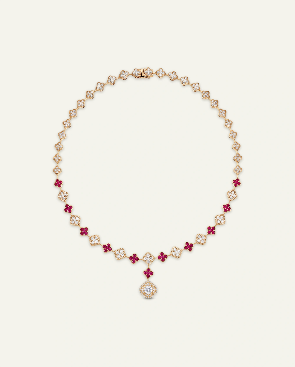 A luxury rose gold necklace featuring alternating floral motifs of white diamonds and deep red rubies, with a central teardrop-shaped ruby pendant, displayed on a clean off-white background.