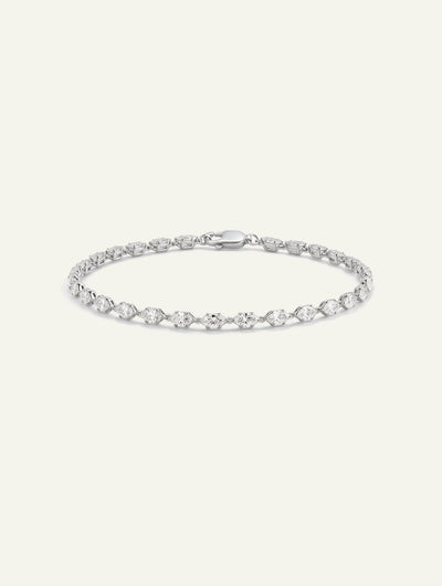 White gold tennis bracelet featuring alternating round and marquise-cut diamonds on an off-white background.