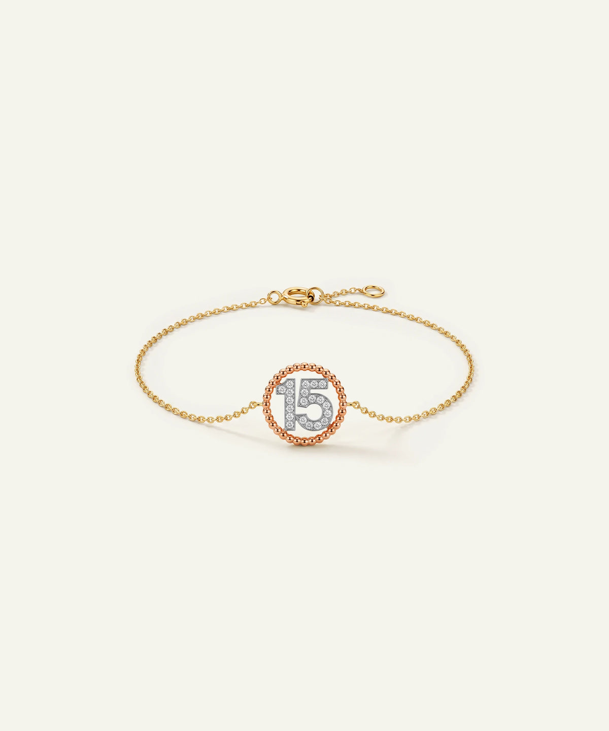 "Gold chain bracelet featuring a circular charm with a diamond-paved '15' and a rose gold border."