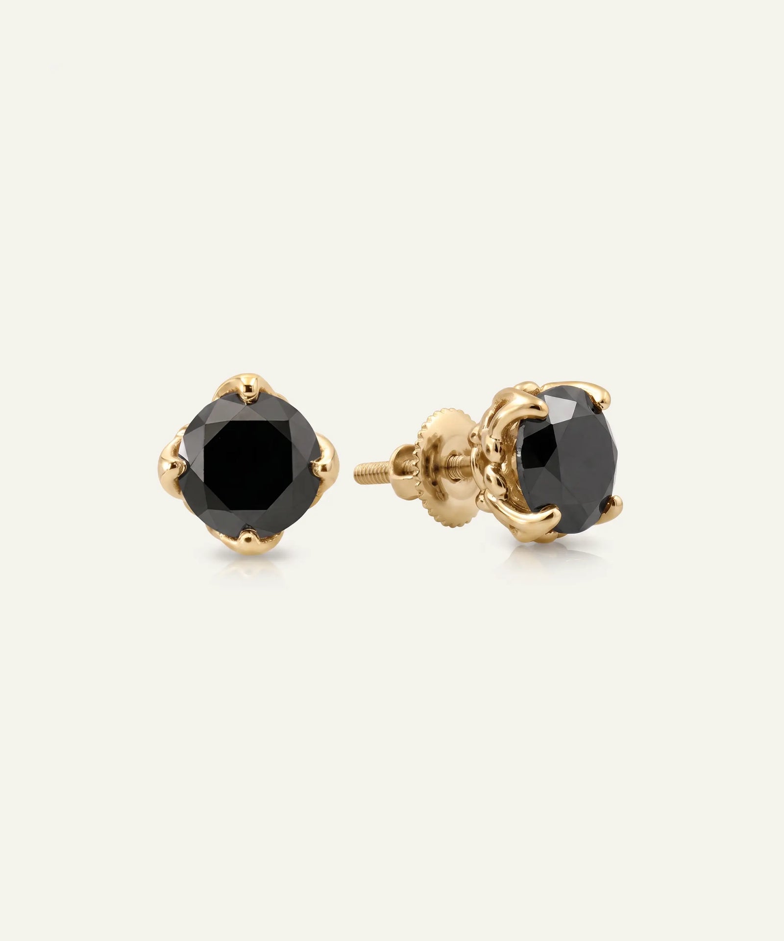 Gold earring with a red gemstone on a white background