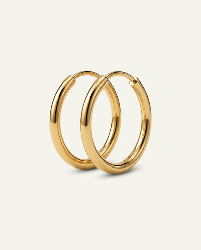A pair of polished gold hoop earrings displayed on a clean, off-white background.