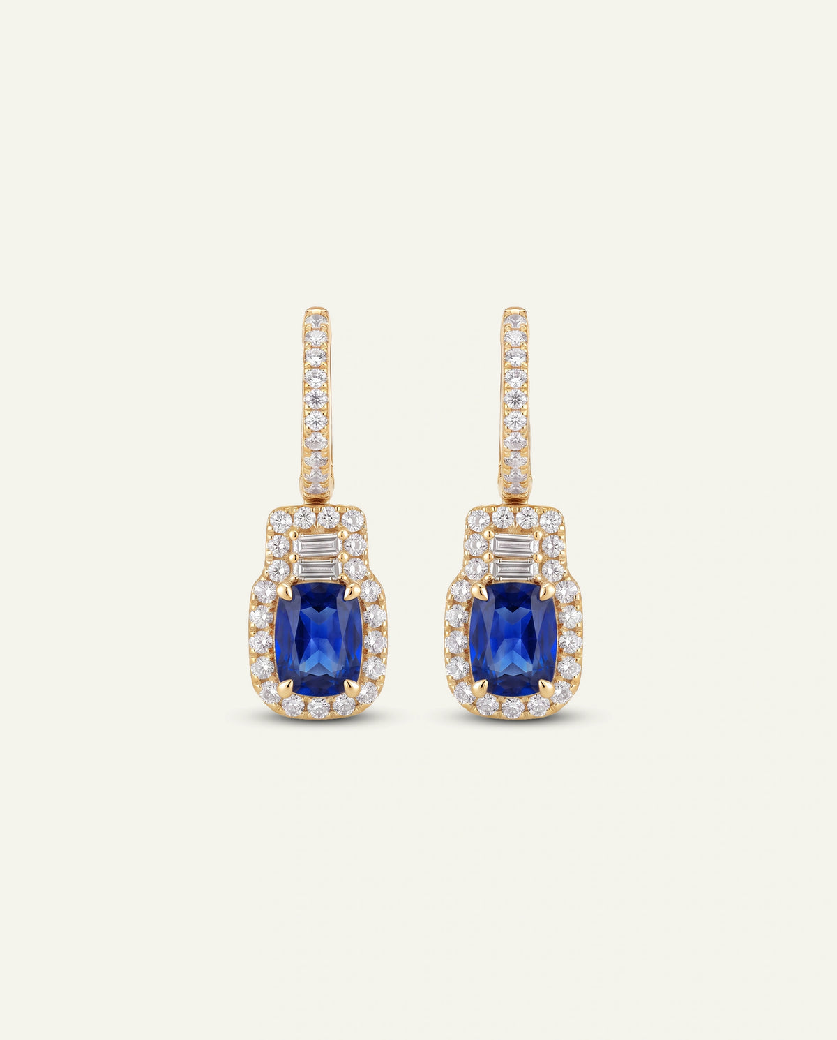 Pair of gold teardrop-shaped earrings on a white background