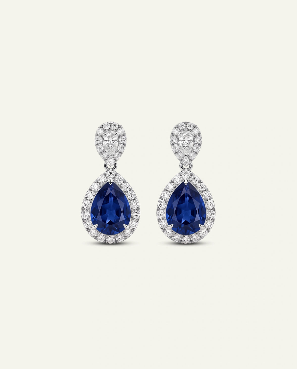 Gold square earrings with clear gemstones on a white background