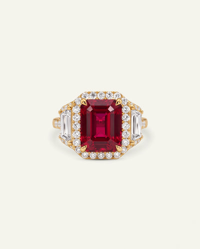 A gold band ring featuring five bezel-set gemstones in pastel shades of pink, light blue, peach, yellow-green, and peach, displayed on a clean white background.
