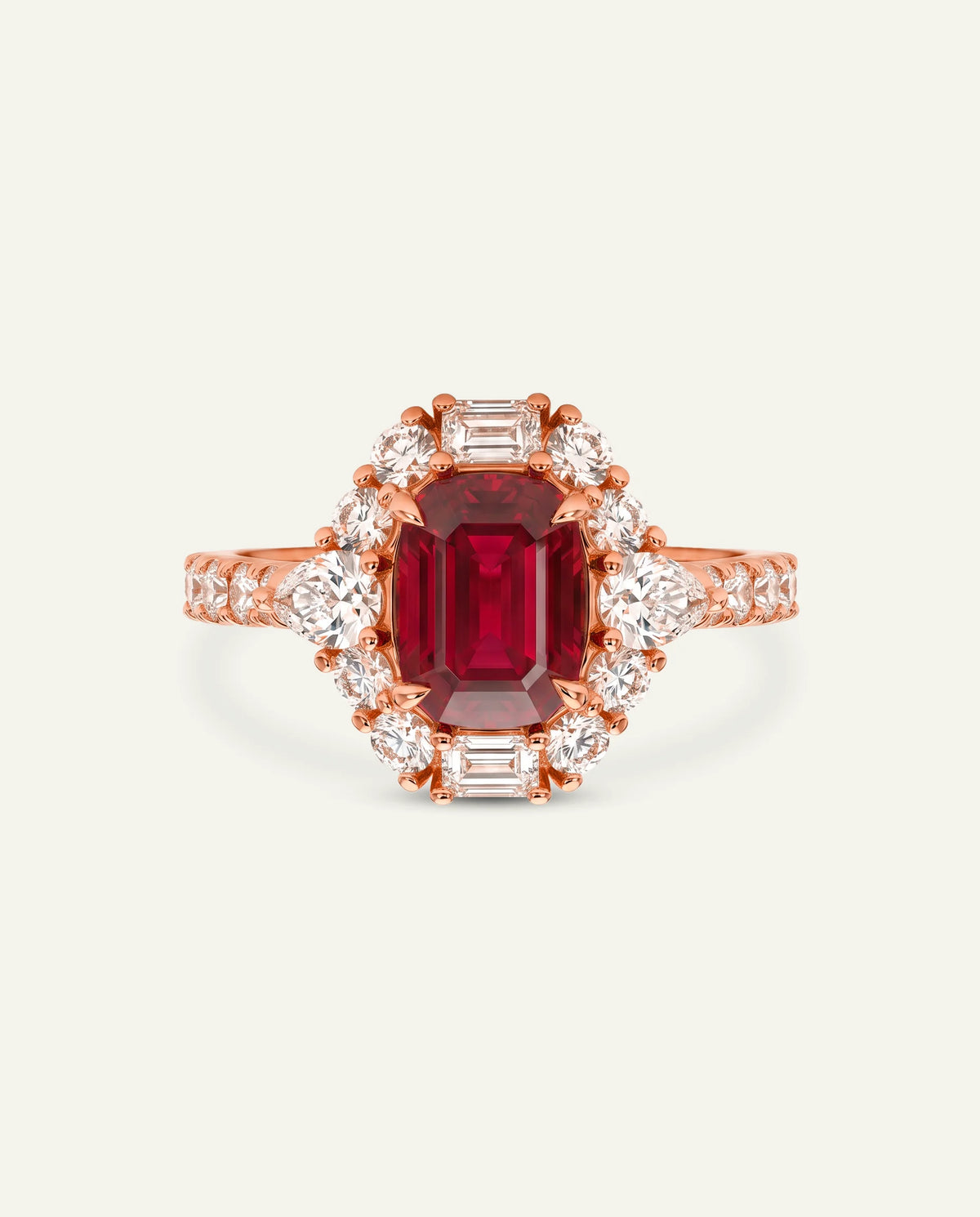 A rose gold ring featuring a large rectangular emerald-cut red ruby center stone, surrounded by a halo of small round diamonds and baguette-cut diamonds, with the band decorated with channel-set diamonds, set against a light off-white background.