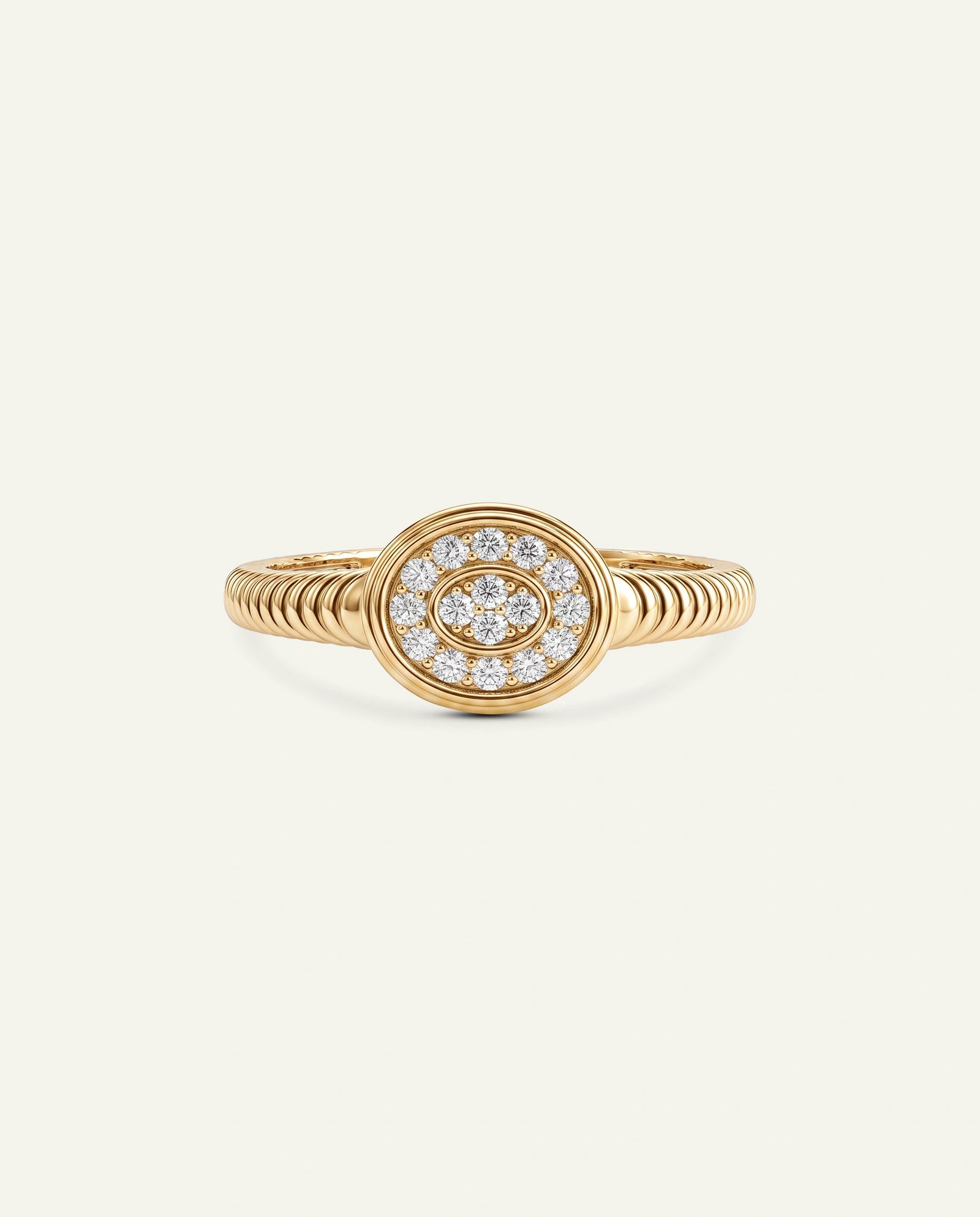 A gold ring featuring a circular design with a central halo of small clear stones and an eye motif, set against a plain off-white background.