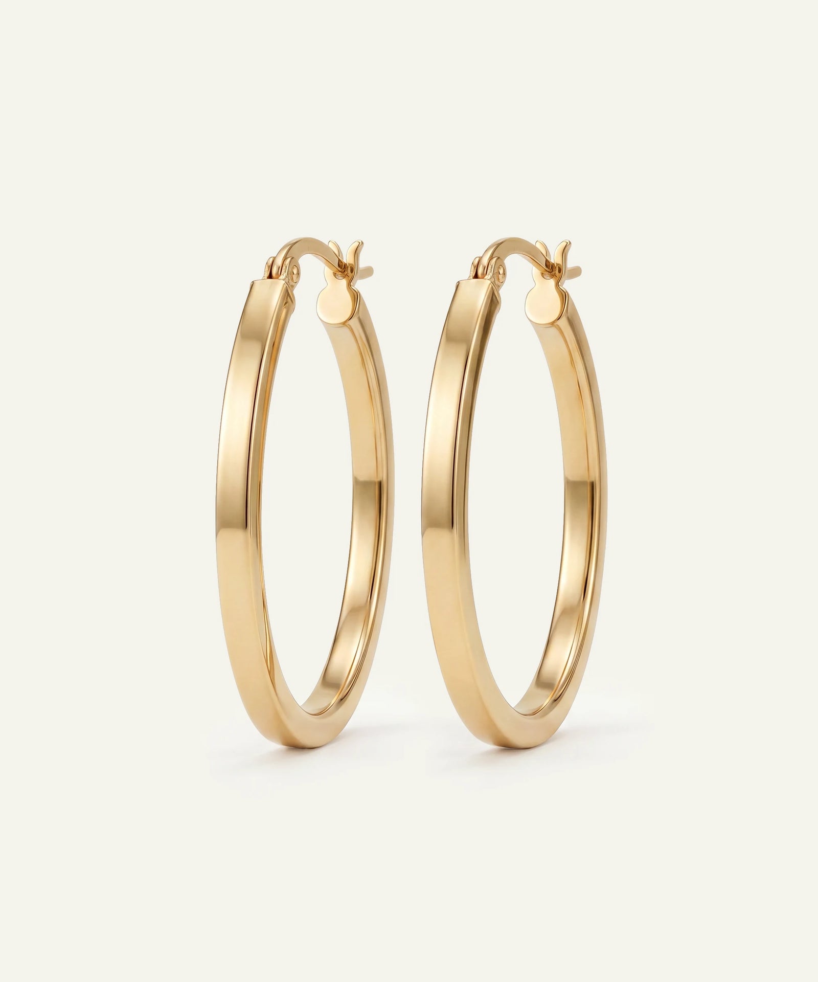 Gold hoop earrings on a light beige background
