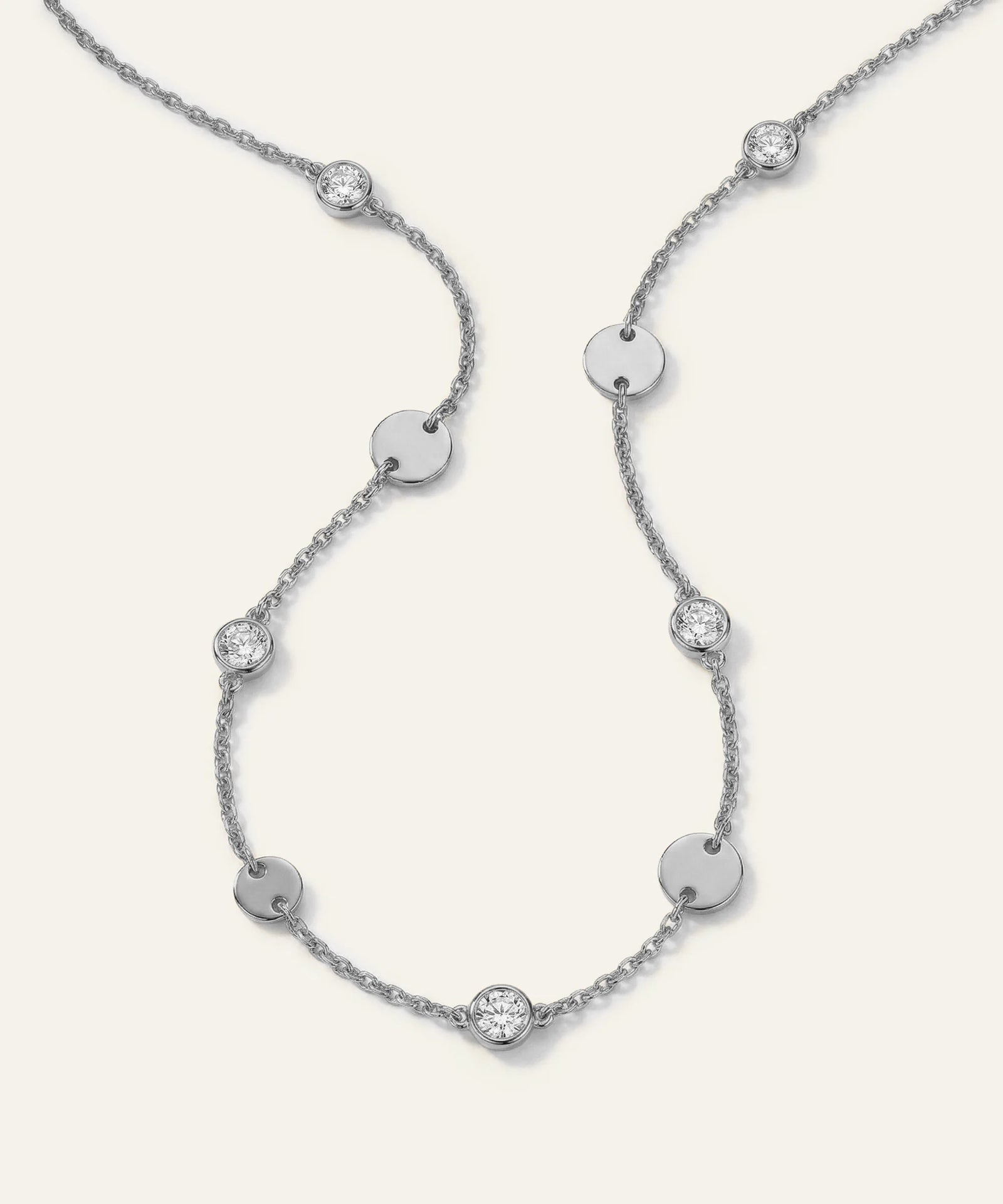Silver necklace with diamond accents on a light gray background