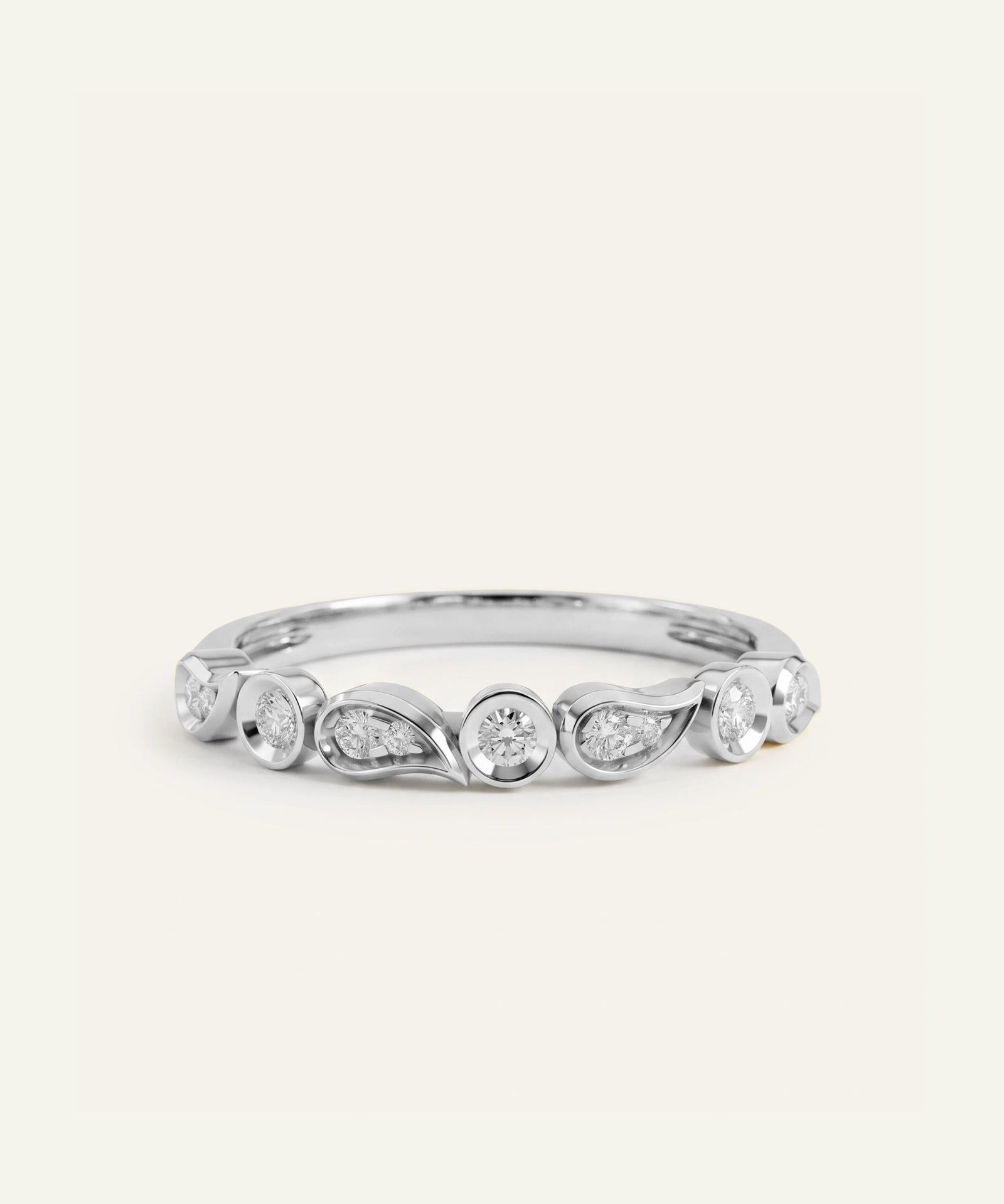 A silver-toned diamond band ring with a wavy, organic design featuring multiple round and marquise-cut diamonds, photographed on a clean, light cream background.