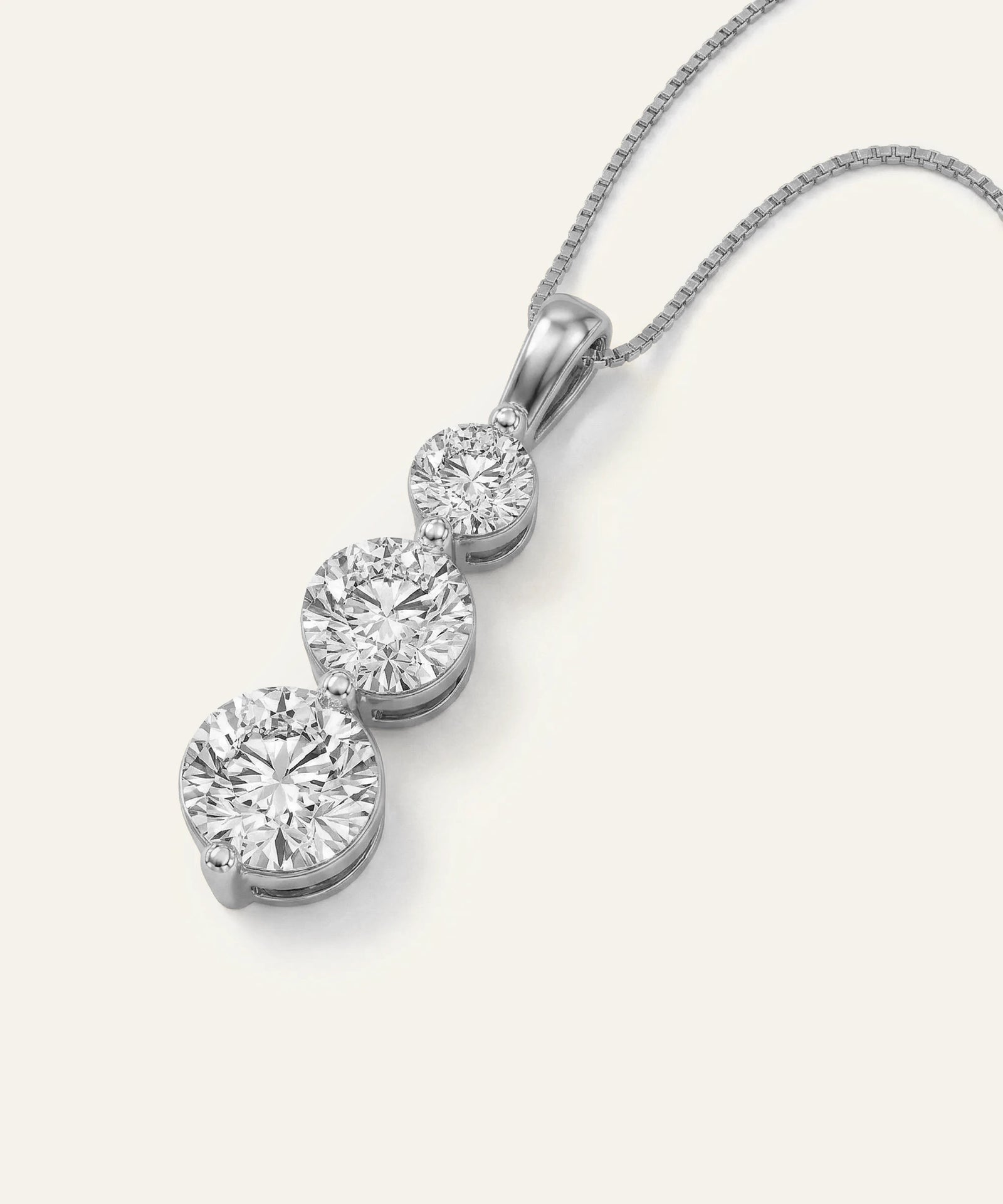 Diamond necklace with three round diamonds on a white background