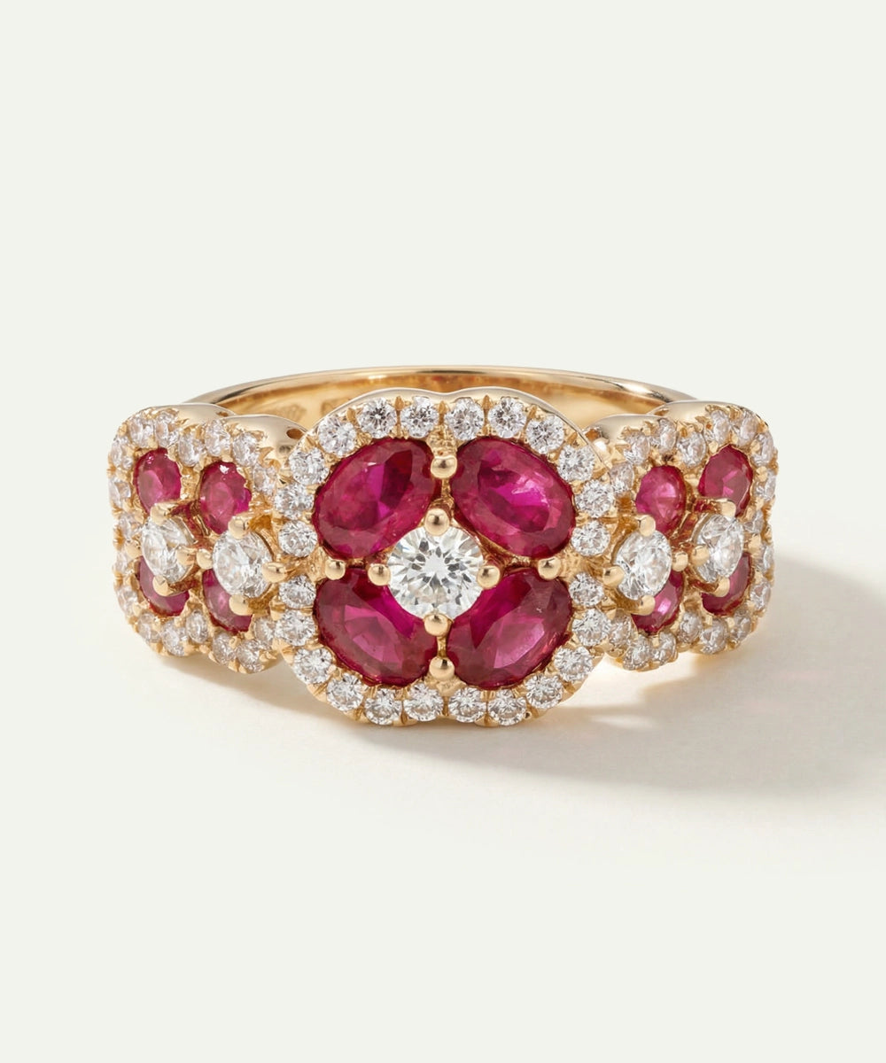 Gold ring with red gemstones and diamonds on a white background