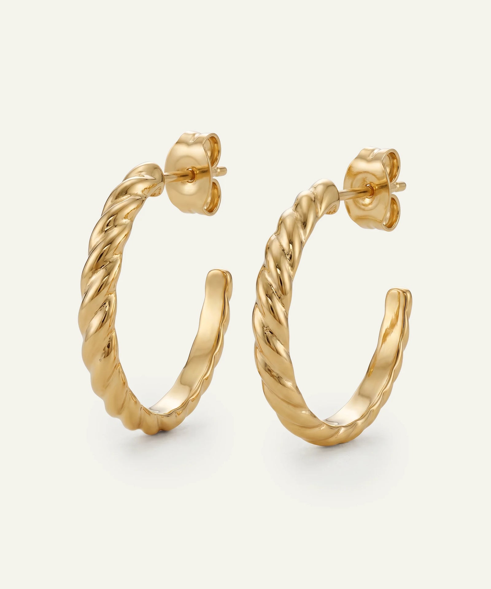 Gold hoop earrings on a light gray background