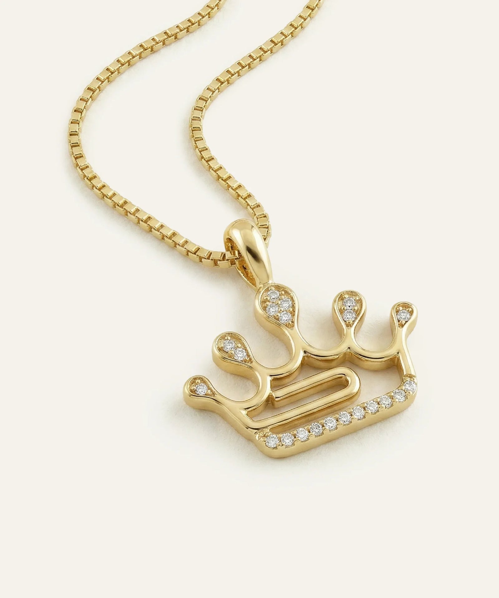 Gold necklace with a unique pendant on a white background