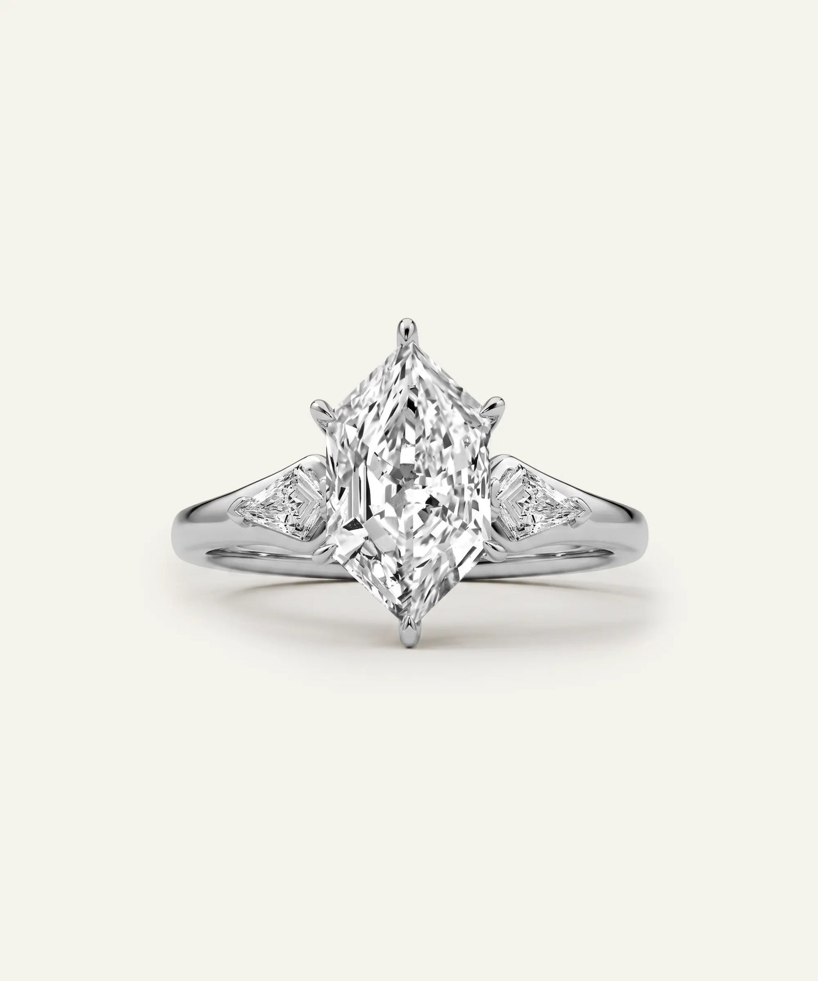 An elegant diamond ring featuring a large marquise-cut center stone with smaller round diamonds set on a polished silver-colored band, presented on a clean off-white background.