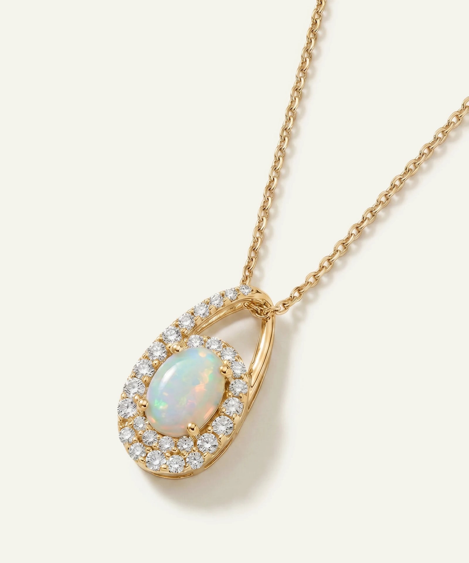 Gold necklace with an opal pendant on a white background
