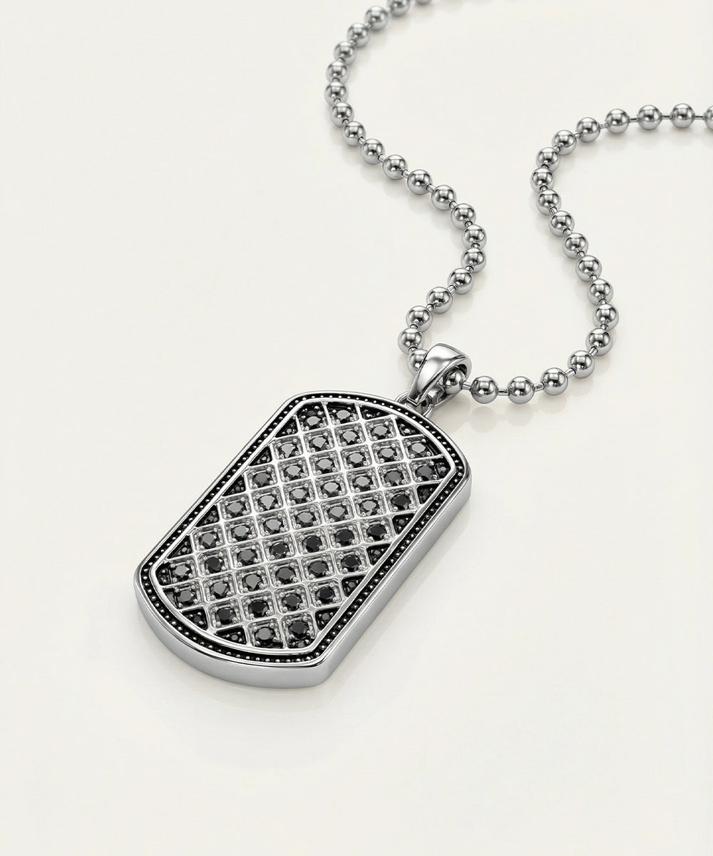 Silver pendant necklace with black gemstones on a white background