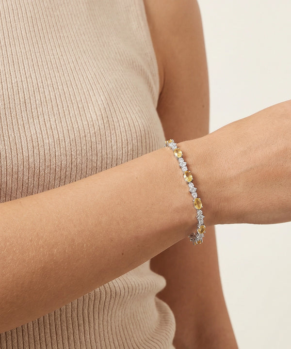 Bracelet with multicolored stones on a wrist against a neutral background
