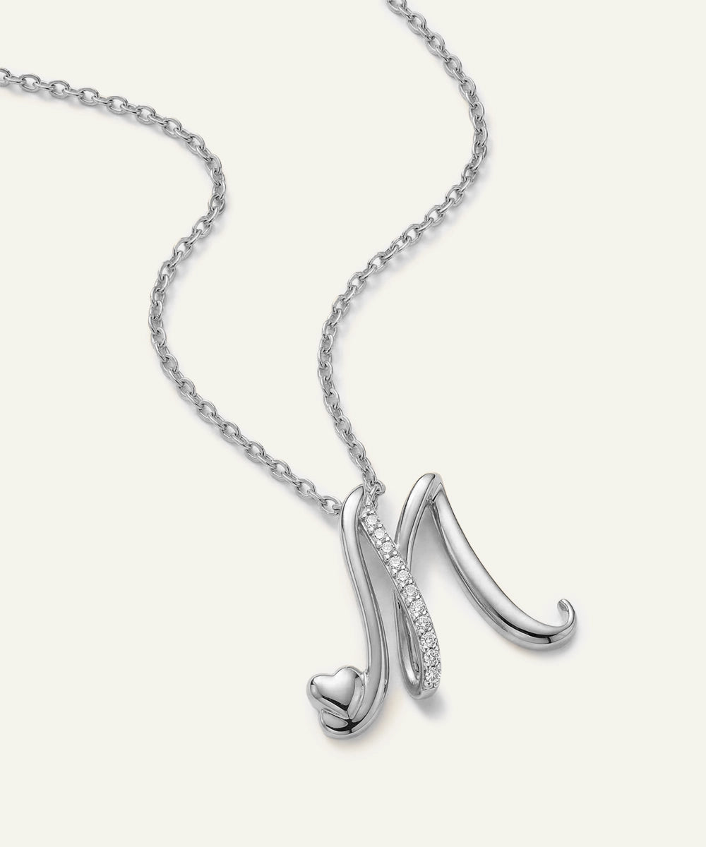 Silver necklace with a heart-shaped pendant on a white background