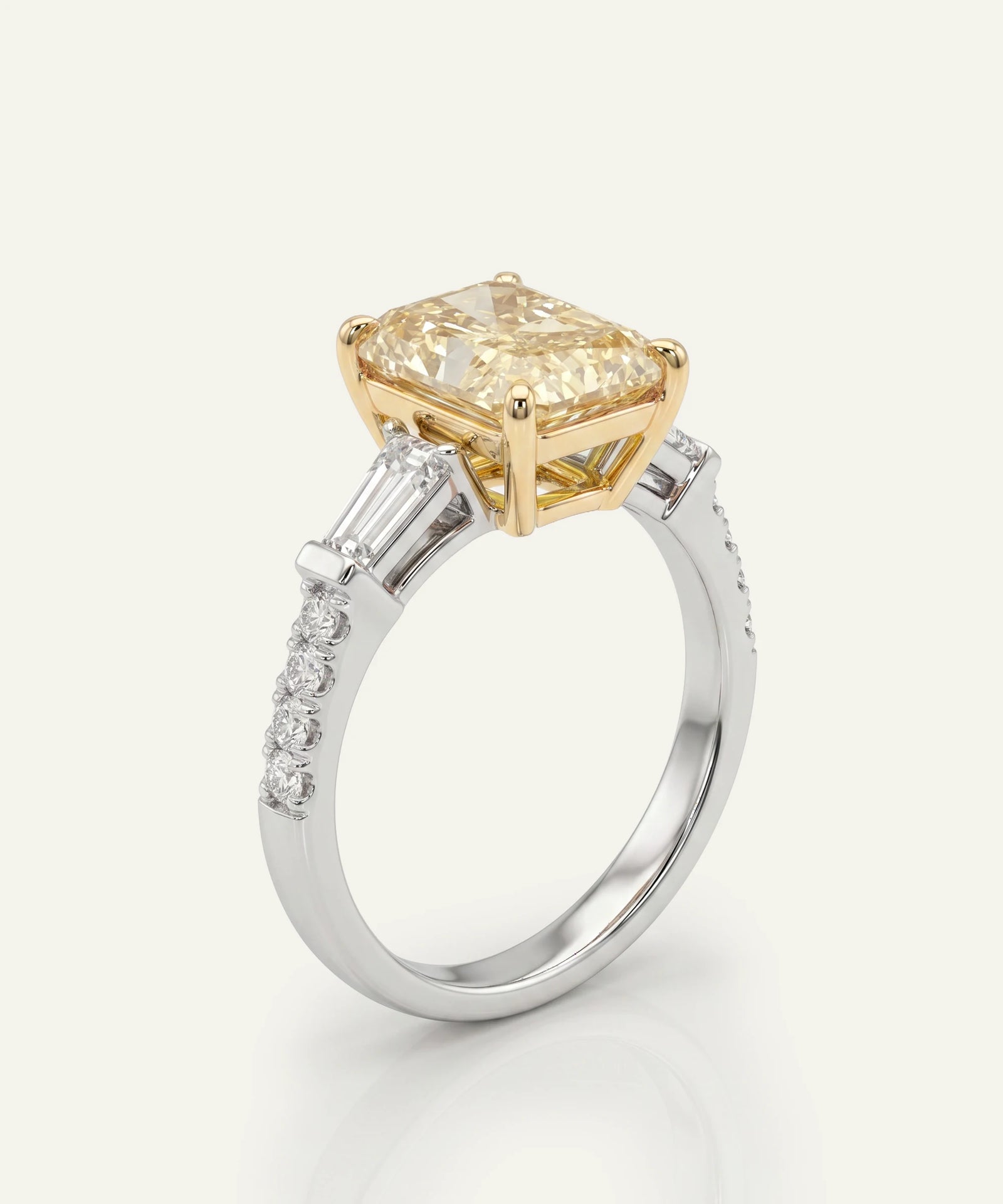 Gold and silver ring with a large yellow diamond on a white background