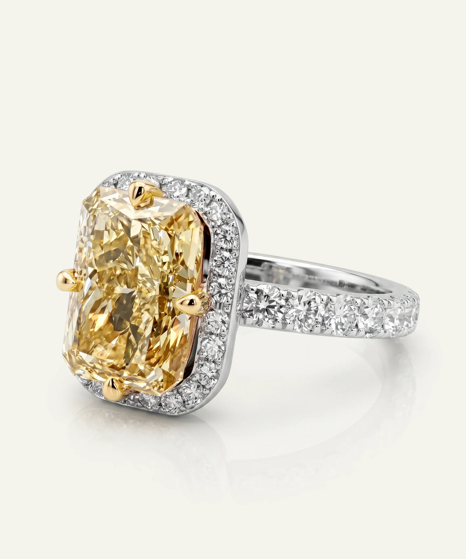 Ring with a yellow gemstone and diamond-studded band on a light background