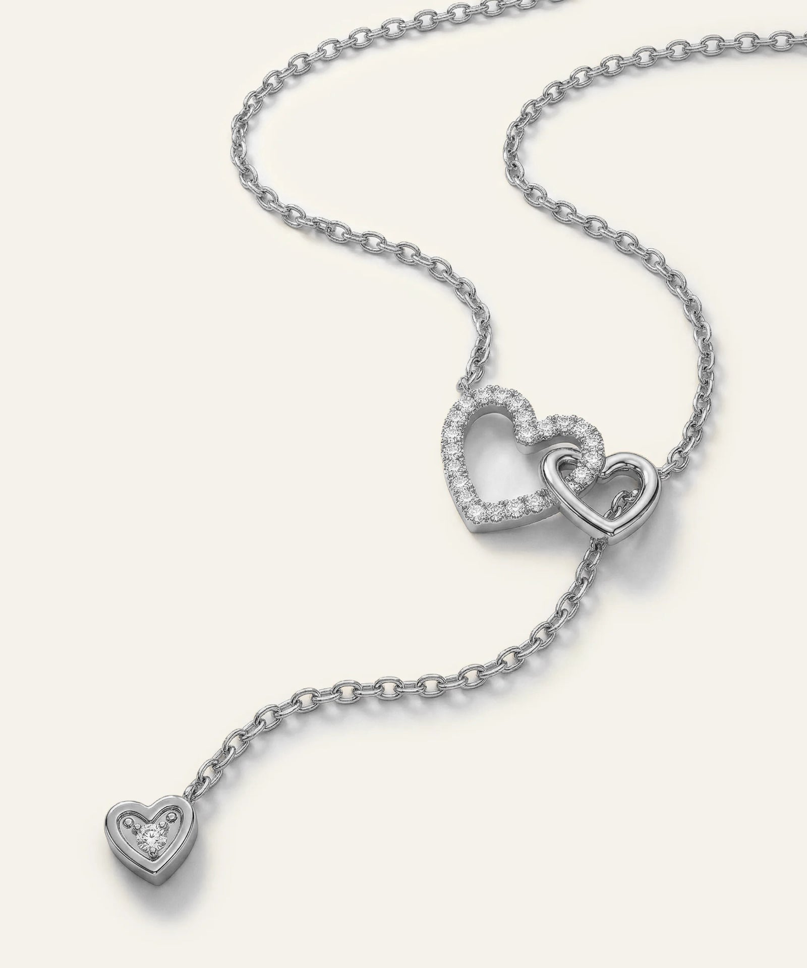 Silver necklace with heart-shaped pendants on a white background