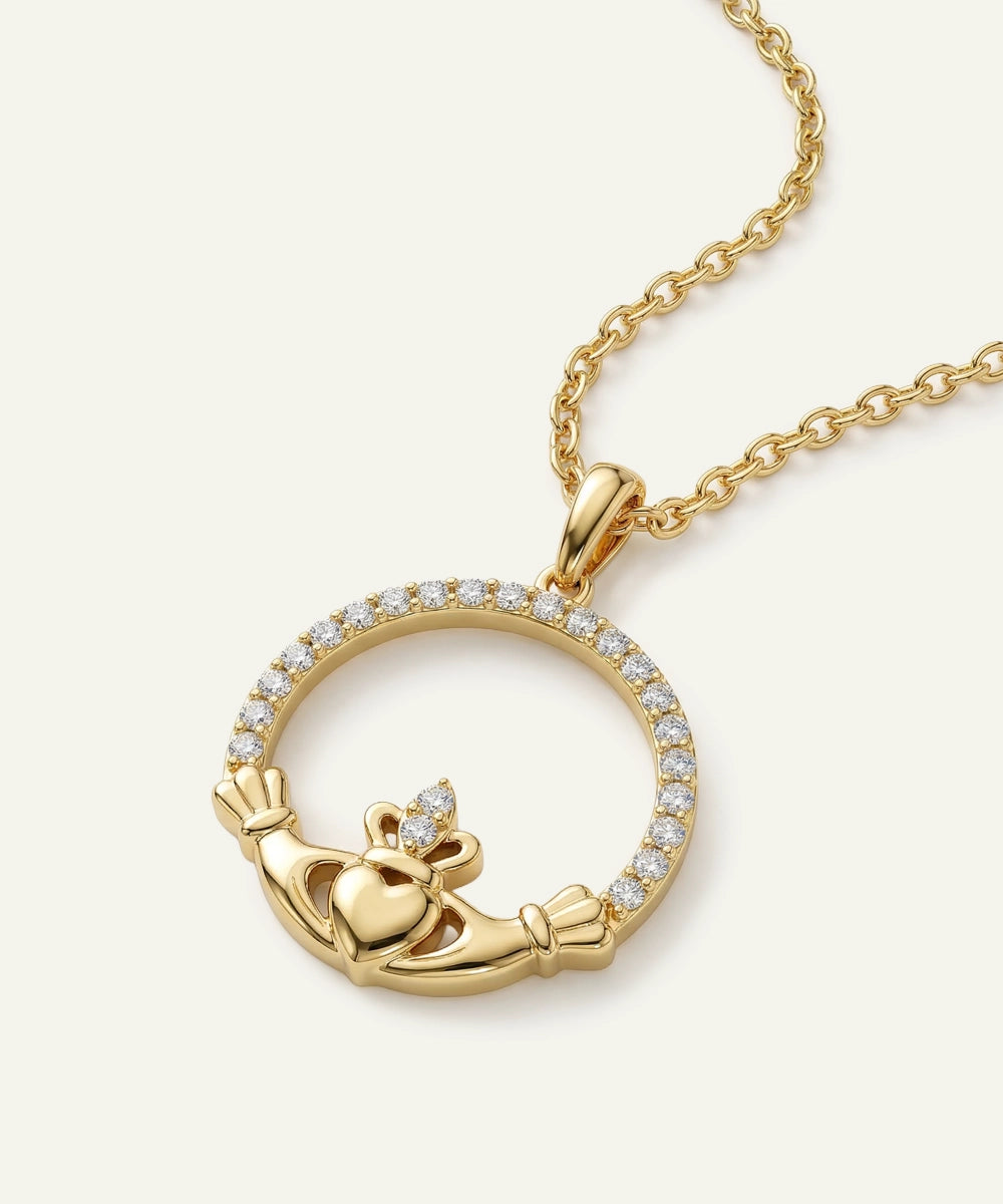 Gold claddagh pendant necklace on a white background
