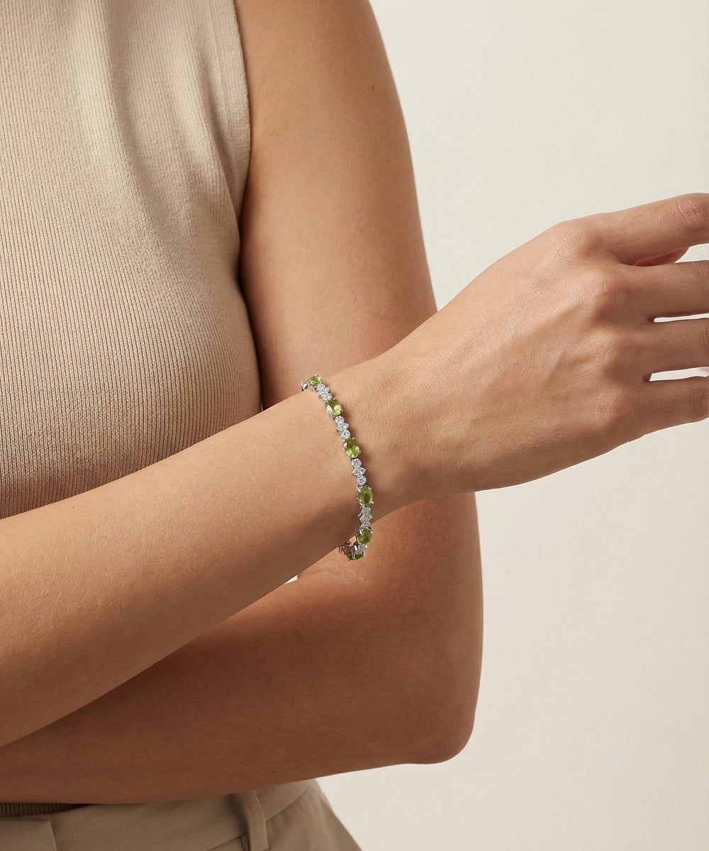 Person wearing a bracelet with small flowers on a neutral background