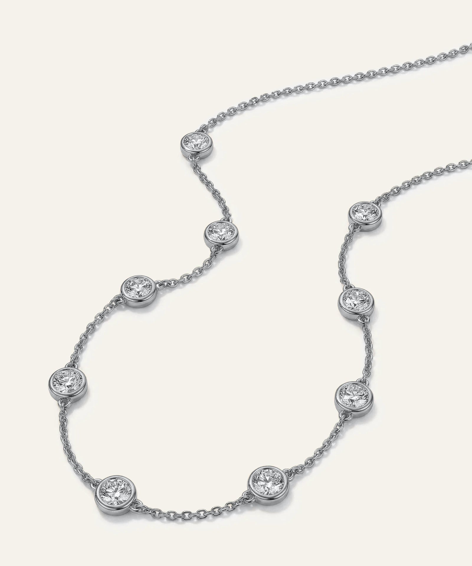 Silver necklace with diamond beads on a white background