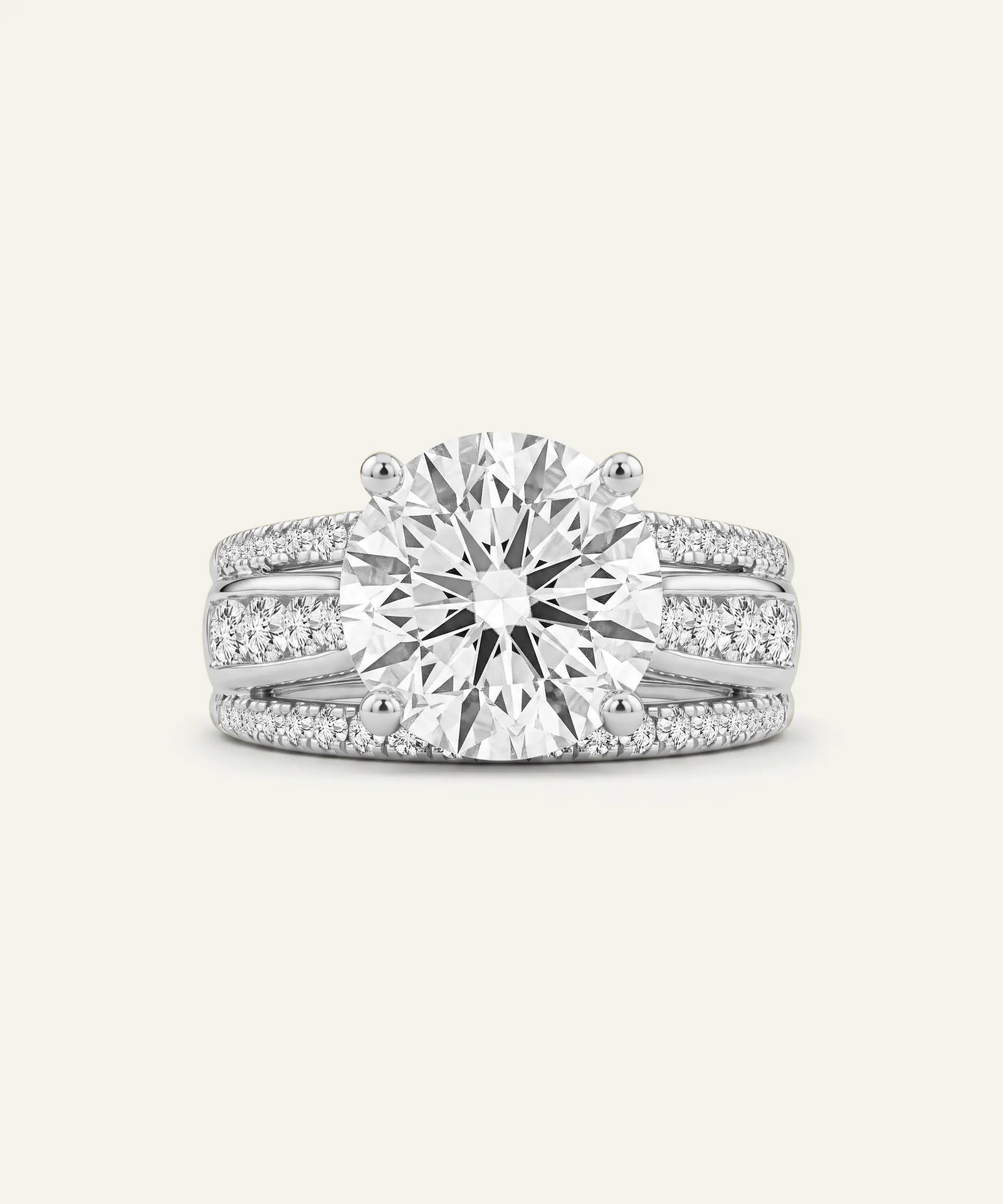 A radiant cut diamond engagement ring in a silver-toned metal, featuring a large center stone and pavé-set accent diamonds along the shank, shown on a light cream background.