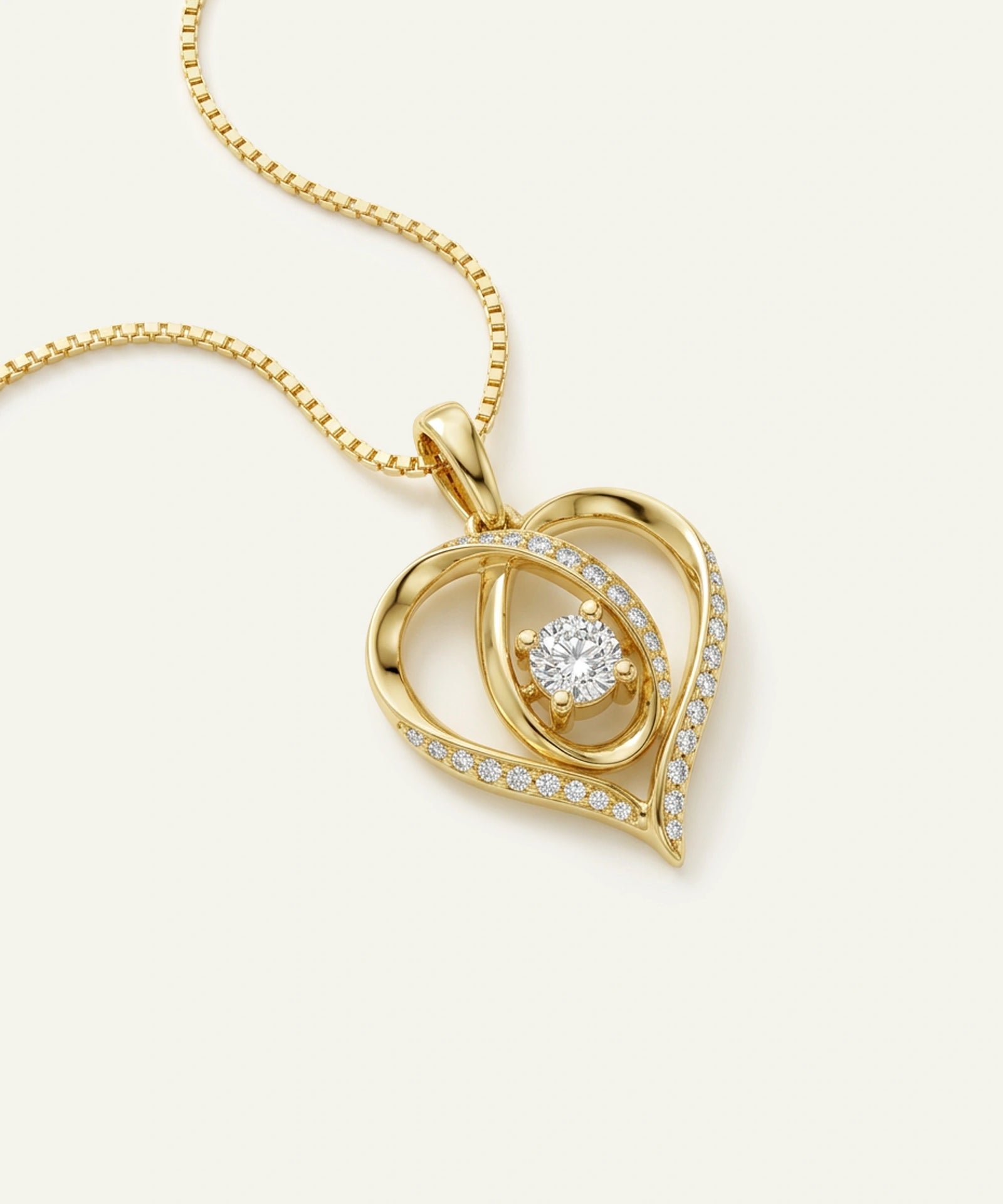 Gold heart-shaped pendant with a diamond on a white background