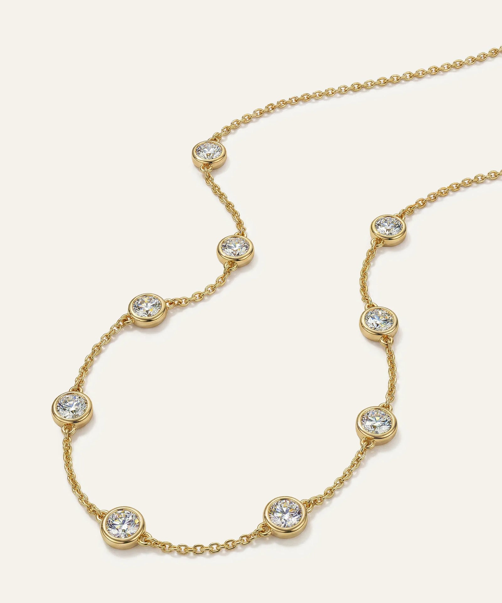 Gold necklace with diamond beads on a white background