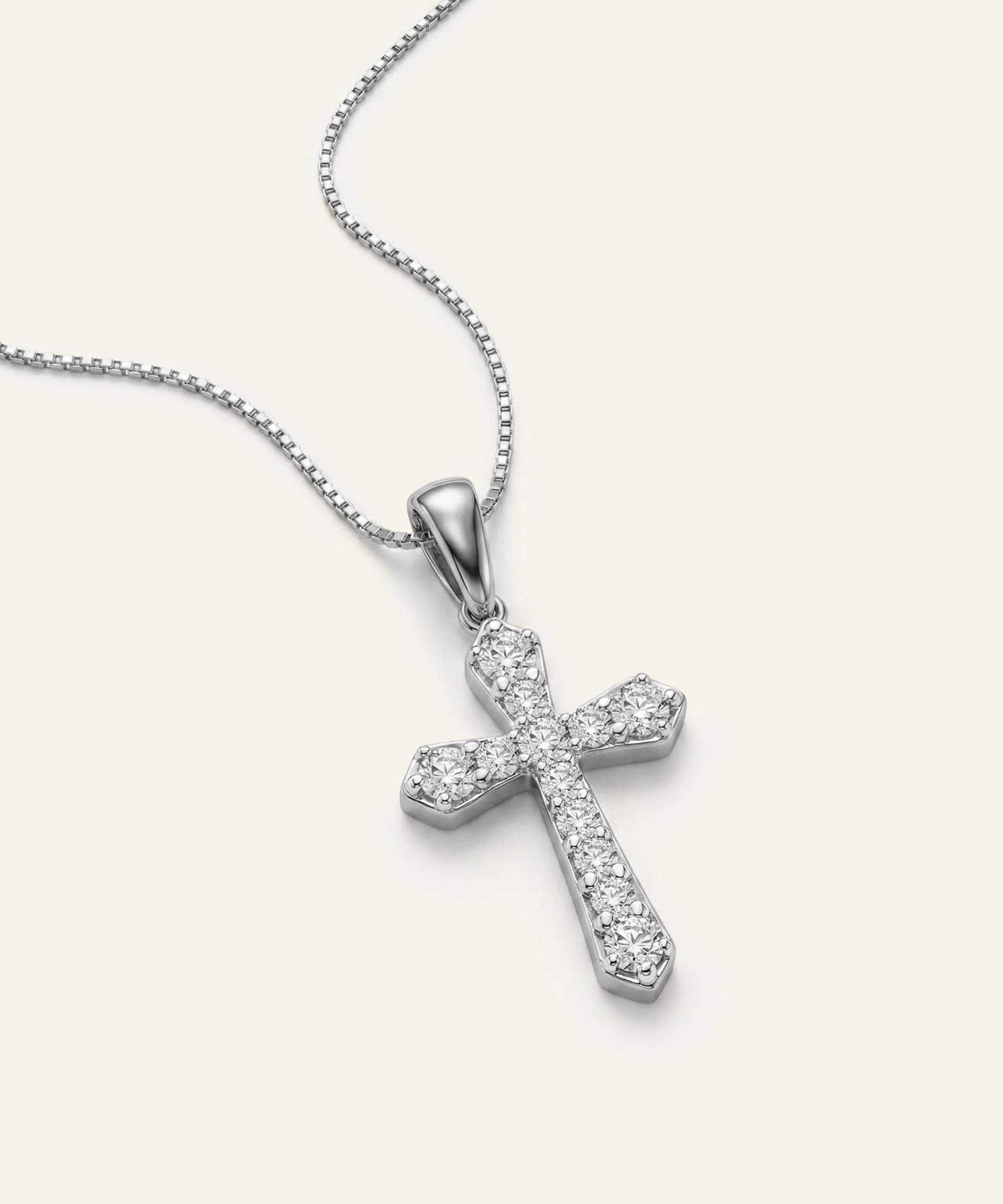 Silver cross pendant necklace on a white background