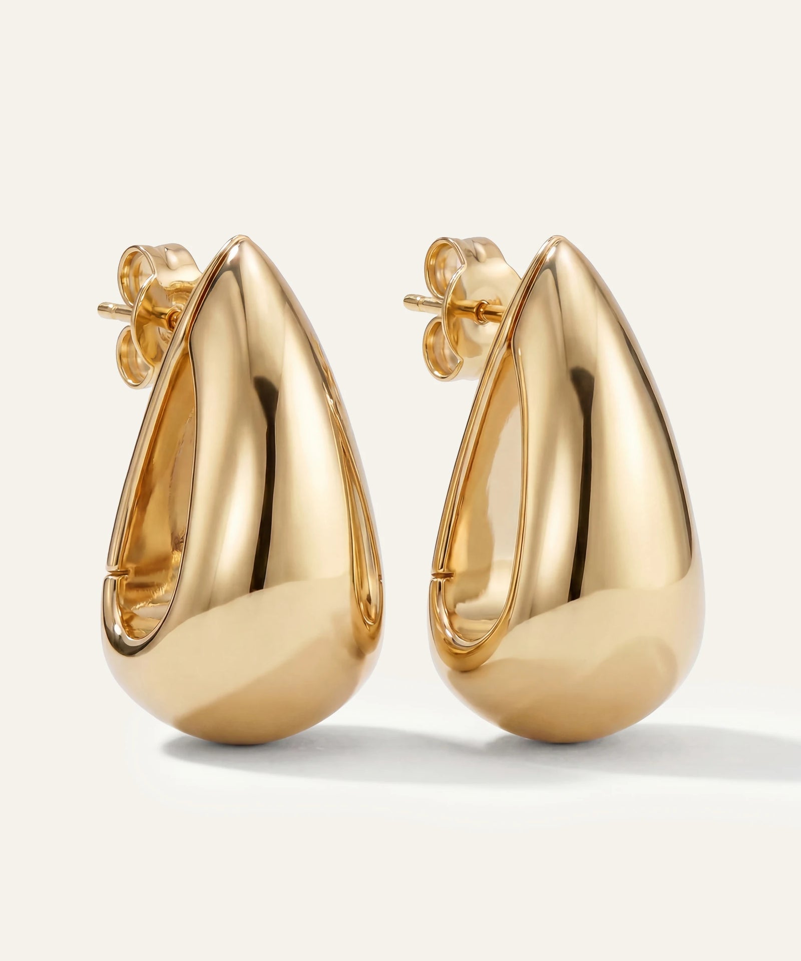 Gold teardrop earrings on a white background