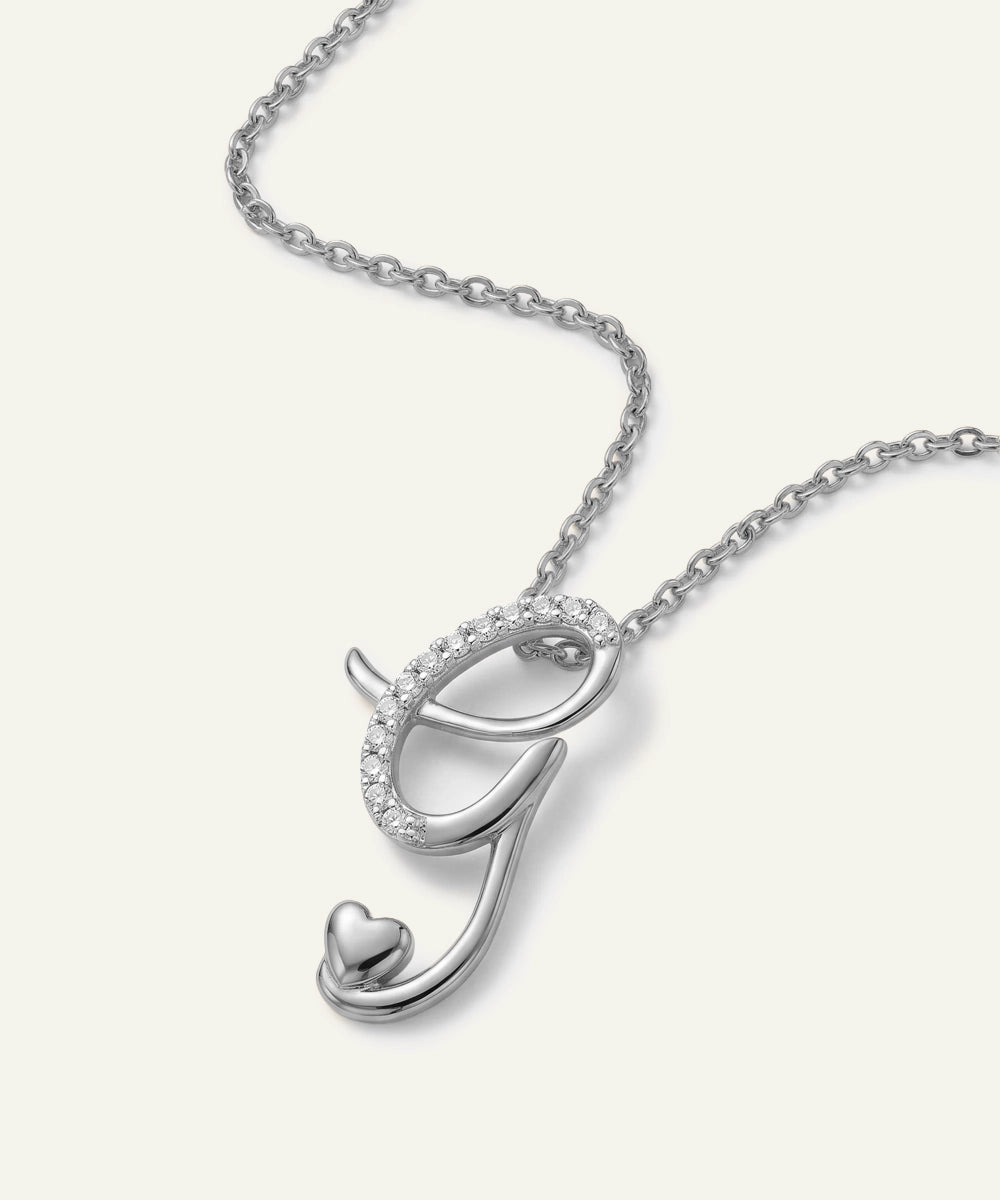 Silver necklace with a heart-shaped pendant on a white background