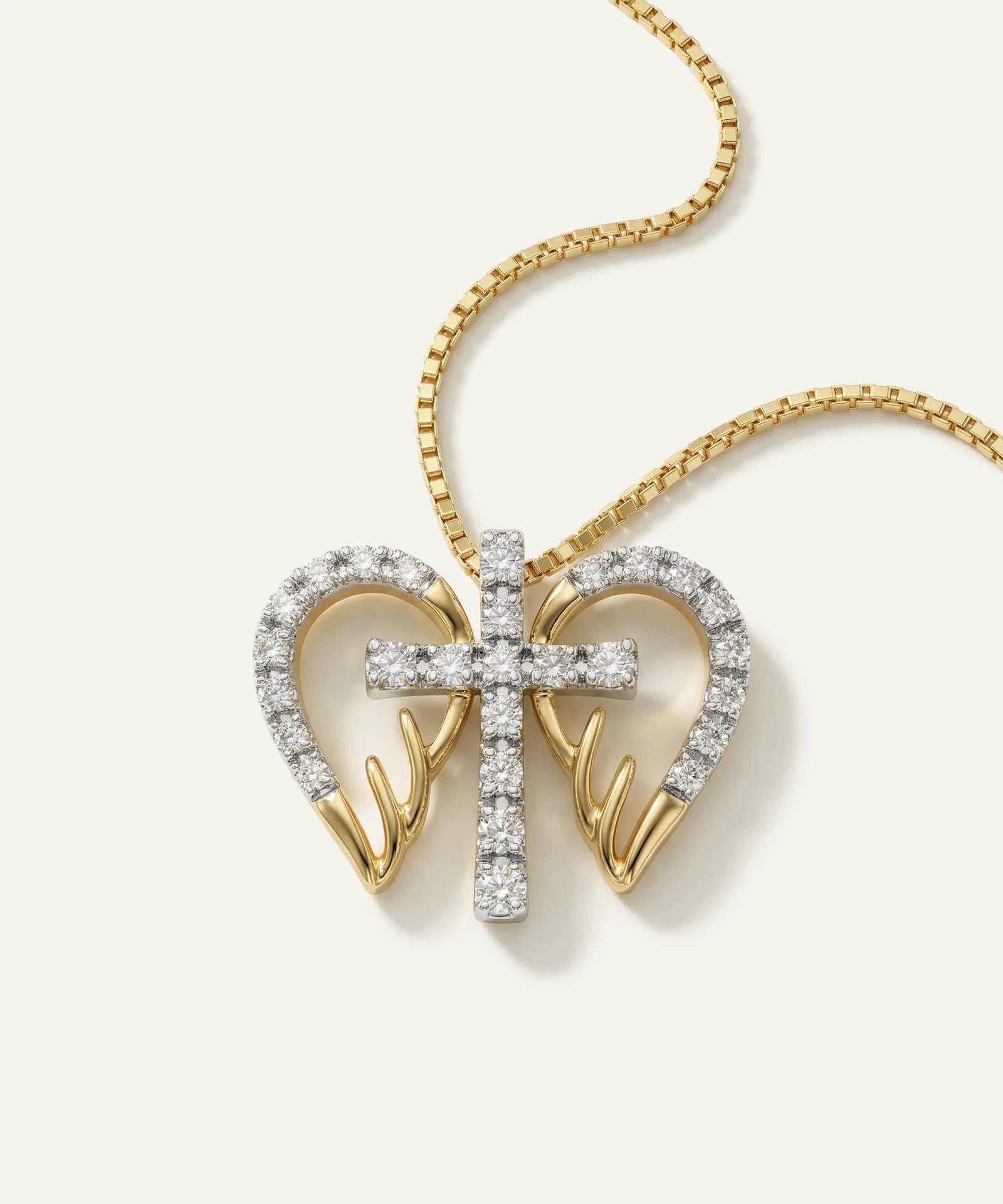 Gold necklace with heart and cross pendant on a white background