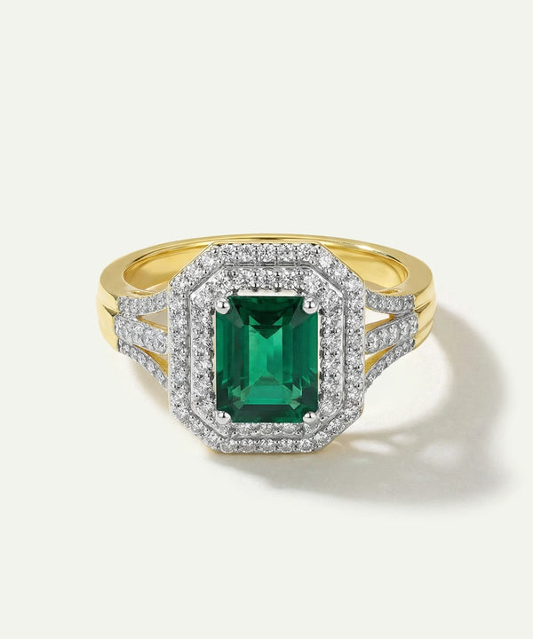 Gold ring with a green gemstone and diamond accents on a white background