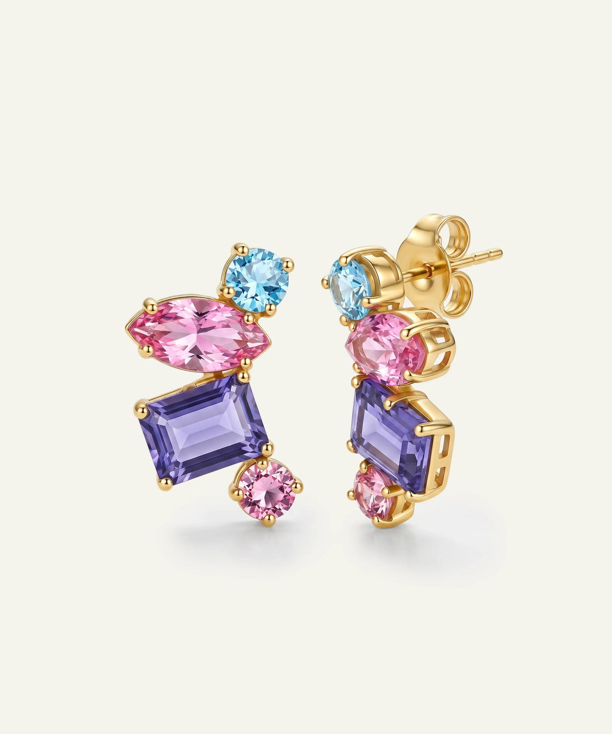 A pair of gold-plated dangle earrings featuring marquise-cut pink, rectangular purple, round light blue, and small round pink gemstones, displayed on a clean off-white background.