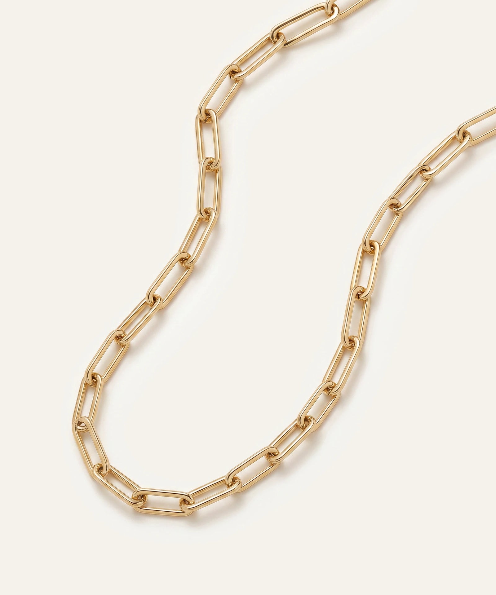 Gold chain necklace on a light beige background